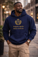 Man wearing a navy hoodie with gold text, Integrity speaks before words do, and logo, standing on a city street.